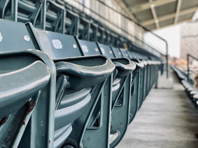 A row of empty stadium seats, folded up, seen from the side along the row.
